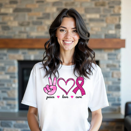 Model wearing white “Peace, Love, Cure” t-shirt in a casual lifestyle setting, confidently showing support for breast cancer awareness