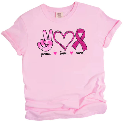 Pink “Peace, Love, Cure” t-shirt flat lay with pink tie-dye peace hand, double-heart, and glittery ribbon icons for breast cancer awareness