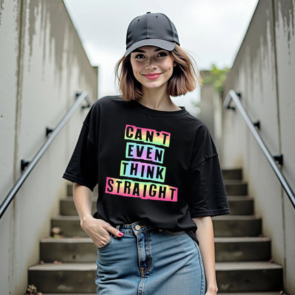 Female model wearing black “Can’t Even Think Straight” Pride t-shirt outdoors, rainbow gradient cutout lettering design, cute and playful LGBTQ graphic tee.