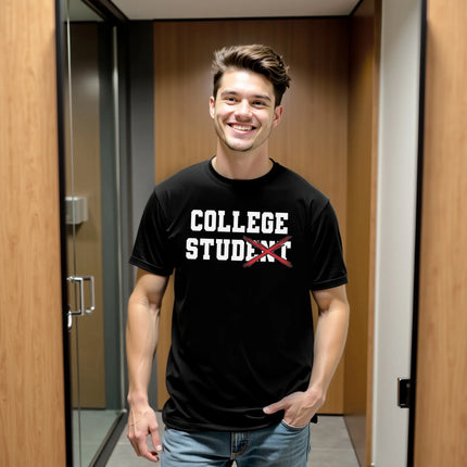 Male model wearing black College Stud varsity t-shirt in dorm room, crossed-out lettering design, funny college humor campus vibe.