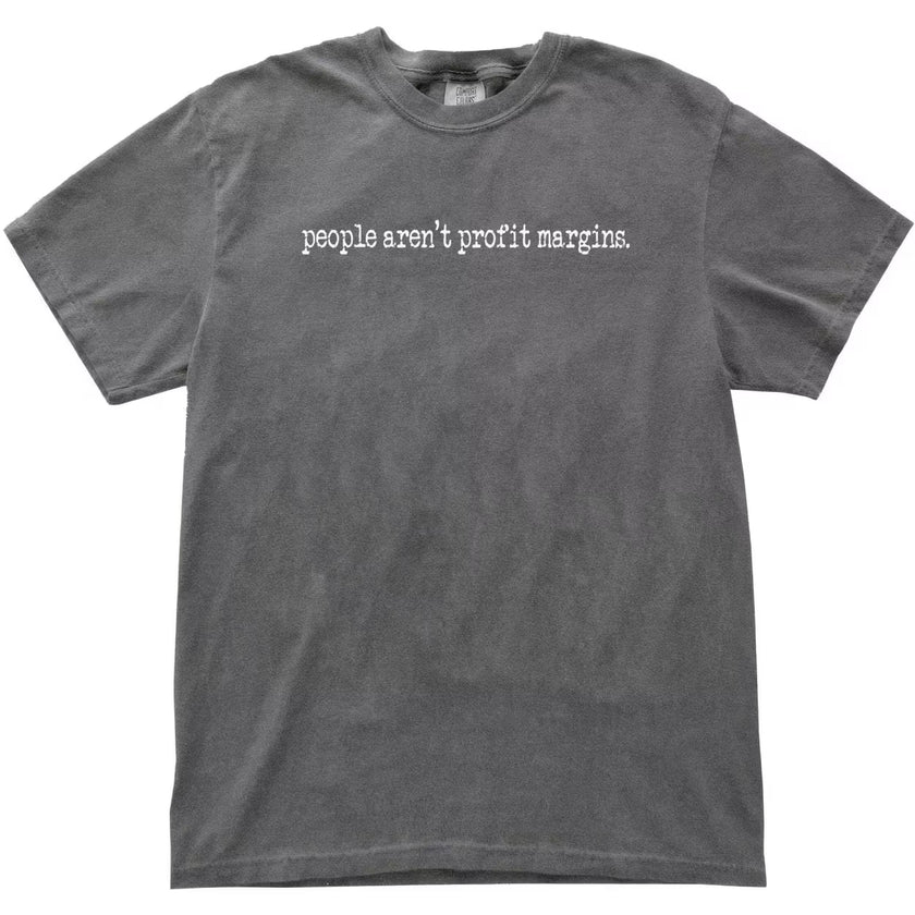 Gray “People Aren’t Profit Margins” t-shirt flat lay featuring neutral tone and strong social justice wording