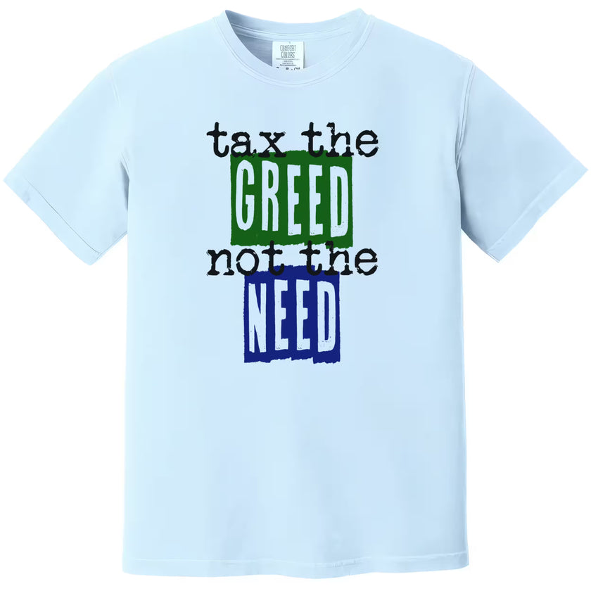 Blue “Tax the Greed, Not the Need” t-shirt flat lay highlighting bold blue and green letters with minimalist social justice design