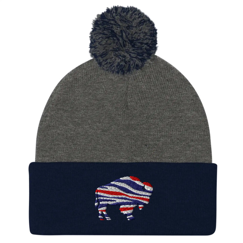 Two-tone navy and grey pom pom beanie with embroidered Buffalo silhouette in red white blue football team color stripes.