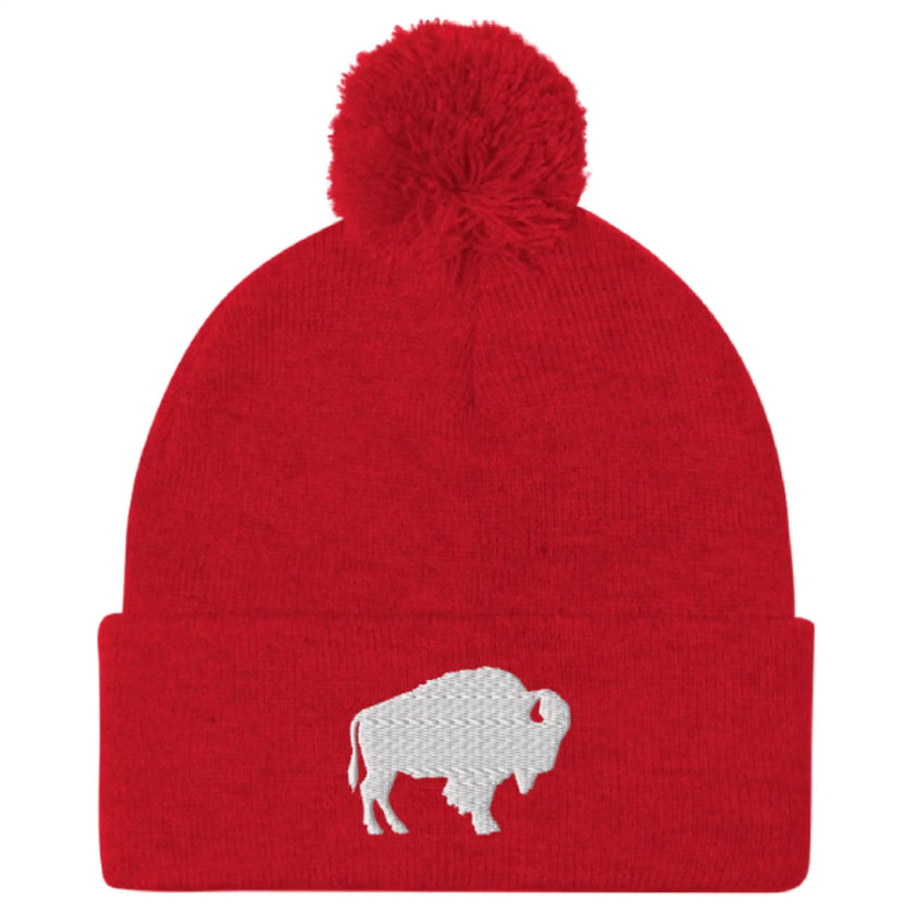 Red pom pom beanie featuring embroidered Buffalo silhouette logo, bold winter hat inspired by Buffalo city and sports culture.