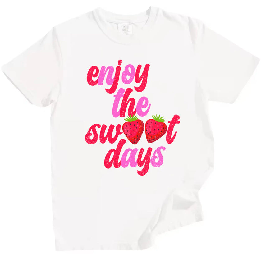 Cute strawberry summer tee in white, ‘Enjoy the Sweet Days’ retro pink and red lettering with fruit detail design.
