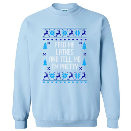 Light blue Hanukkah sweatshirt with ‘Feed Me Latkes and Tell Me I’m Pretty’ ugly sweater inspired design, knitted-look font with reindeer and snowflakes for cozy holiday apparel.