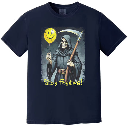 Navy “Stay Positive” grim reaper t-shirt flat lay with ironic reaper illustration holding smiley balloon, edgy humorous statement tee