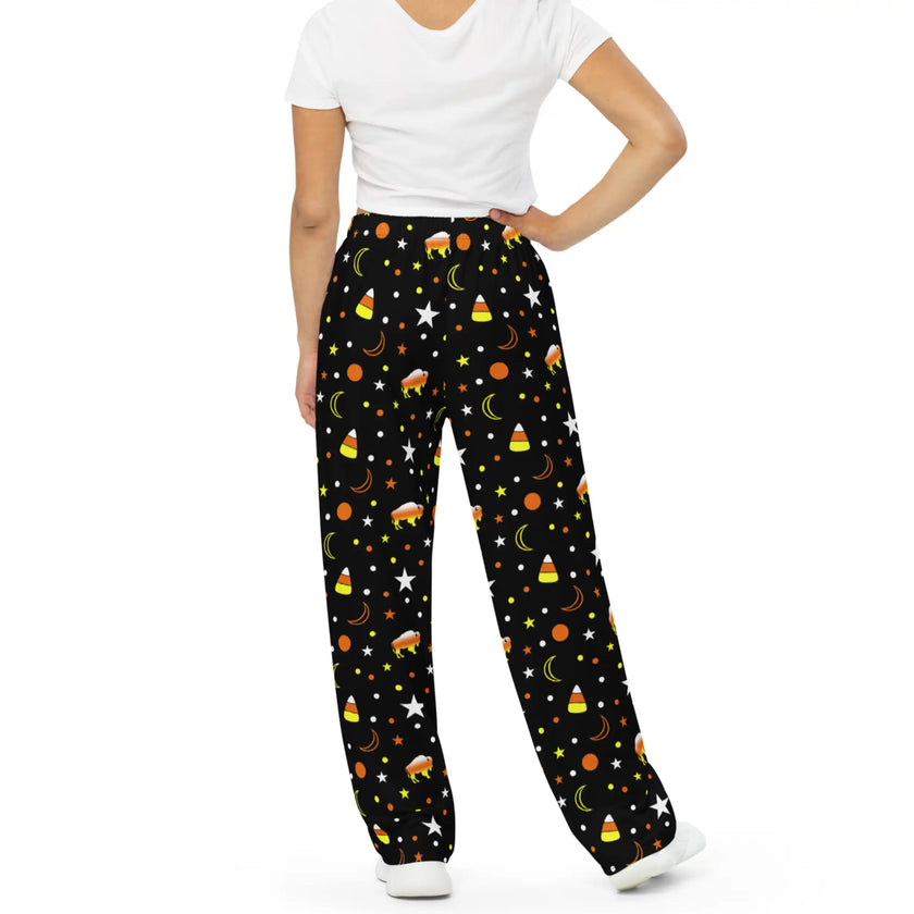 Back view of Buffalo Halloween pajama pants with spooky candy corn color pattern featuring orange yellow white buffaloes, candy corn shapes, stars, and moons
