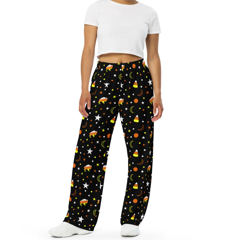 Black Halloween lounge pants featuring candy corn inspired Buffalo silhouettes in orange yellow and white with repeating candy corns, stars, moons, and festive dots