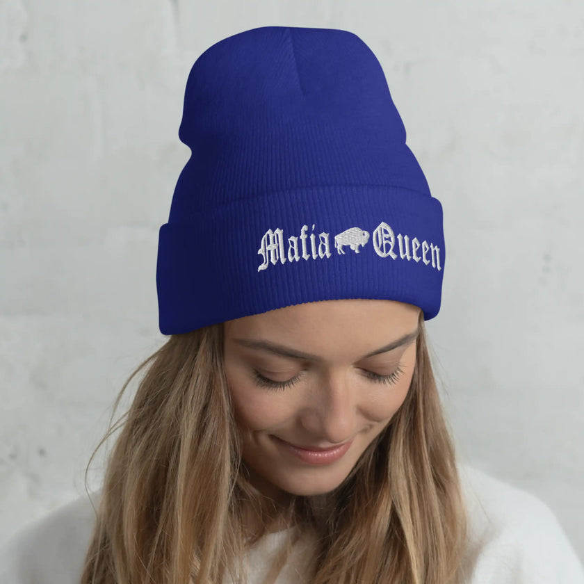 Woman wearing a blue Buffalo football beanie featuring embroidered white ‘Mafia Queen’ lettering with a Buffalo silhouette, warm winter style for a proud fan.