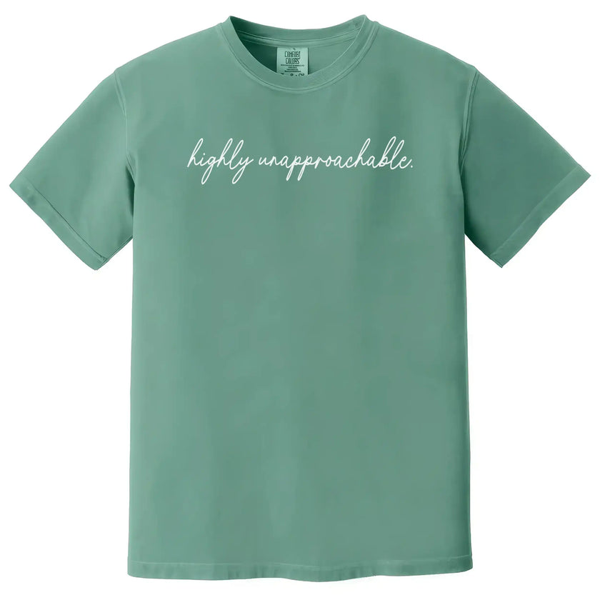 Green “Highly Unapproachable” t-shirt flat lay with clean script text and confident sarcastic vibe