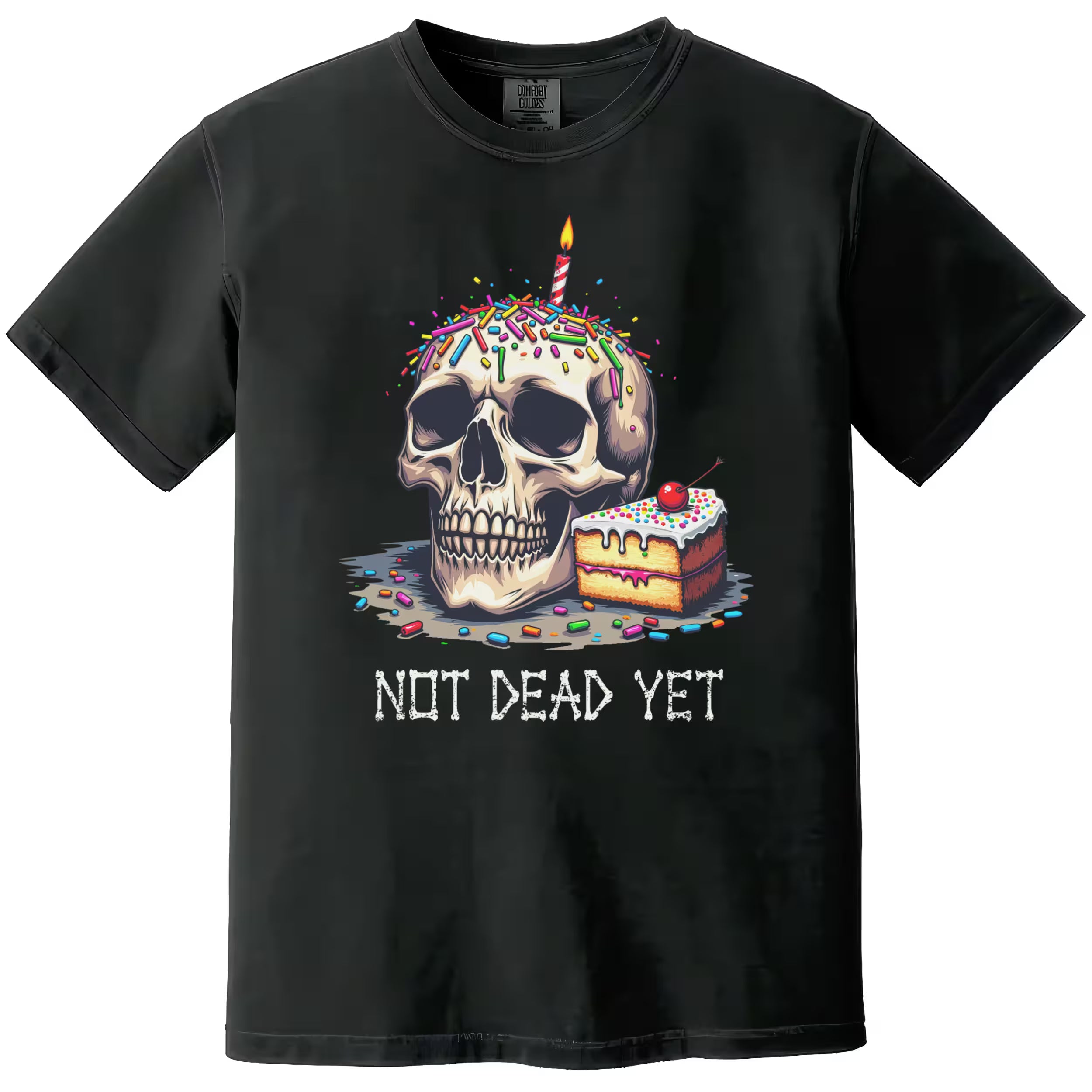 Black “Not Dead Yet” t-shirt flat lay showcasing skull with lit birthday candle, rainbow sprinkles, and cake slice, funny dark humor birthday design