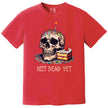 Red “Not Dead Yet” t-shirt flat lay featuring skull with lit birthday candle, rainbow sprinkles, and slice of cake, dark humor birthday design