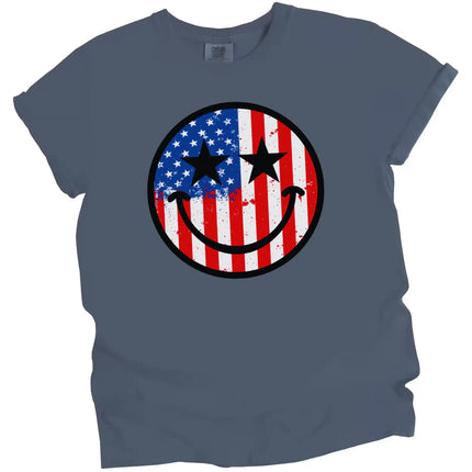 July 4th graphic tee in dark blue, smiling face with paint splatter American flag design and star eyes, casual patriotic shirt.