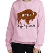 Woman wearing a light pink Buffalo football sweatshirt featuring a playful brown buffalo football design and feminine black script lettering, cute fan fashion with a girly twist.