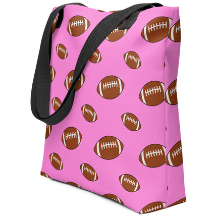 Side view of pink football print carryall bag with repeating brown football pattern in different sizes, versatile design for shopping, groceries, books, or travel.