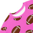 Close-up of pink fabric showing alternating large and small brown football pattern in soft all-over print design with cozy texture detail.