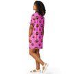 Left side view of model wearing pink football pattern oversized sleepwear with alternating large and small brown football print design.