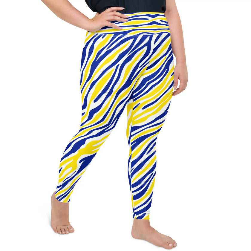 Woman posing in extended-size women's plus Buffalo hockey leggings with colorful blue and gold stripes, demonstrating flexible movement and comfortable activewear styling.