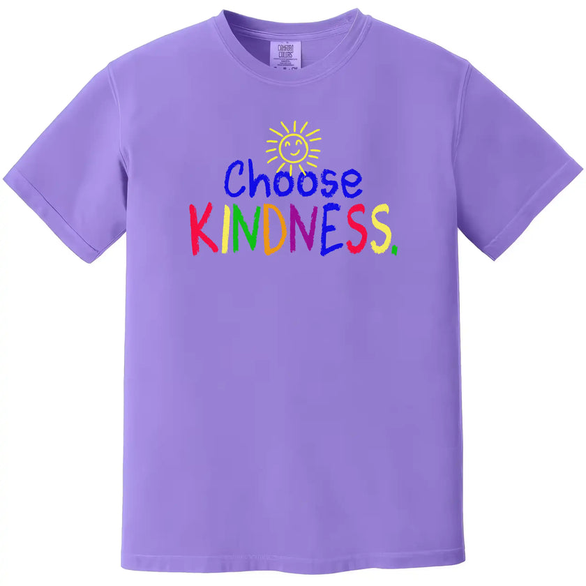 Purple “Choose Kindness” t-shirt flat lay highlighting rainbow crayon font and playful sun illustration for an uplifting look