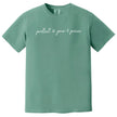 Green “Protect Your Peace” t-shirt flat lay with subtle peace icon details and elegant script font for a simple, mindful design