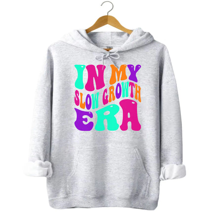 Gray “In My Slow Growth Era” hoodie showcasing bright retro lettering and positive affirmation style for everyday comfort