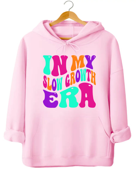 Pink “In My Slow Growth Era” hoodie with bright neon retro lettering, uplifting vibe for women embracing personal growth and cozy everyday wear