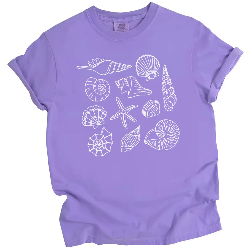 Women’s seashell summer shirt in purple, ocean shell illustrations arranged in a clean minimalist coastal beach design.