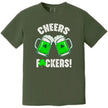 Green St. Patrick’s Day “Cheers Fuckers!” t-shirt flat lay with bold holiday-themed lettering and clinking green beer mugs