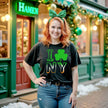 Female model wearing black I Shamrock NY St. Patrick’s Day t-shirt standing outside in front of an Irish pub celebrating the holiday