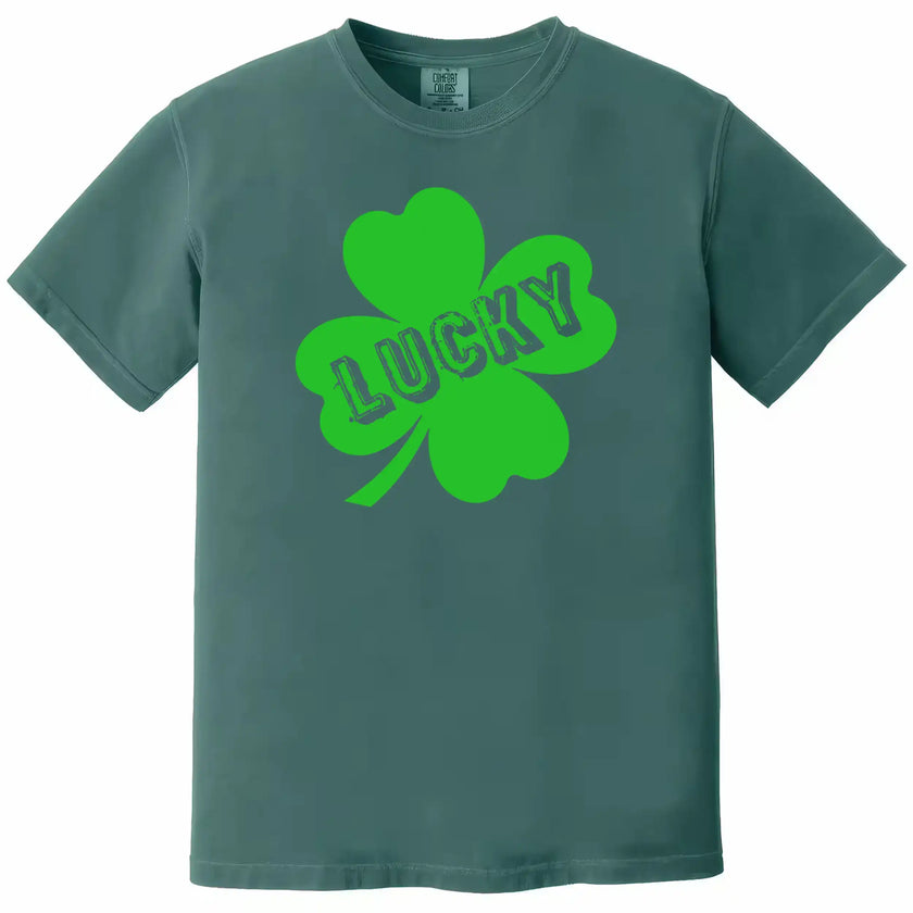 Green St. Patrick’s Day Lucky t-shirt flat lay featuring a large clover and bold cut-out “Lucky” design