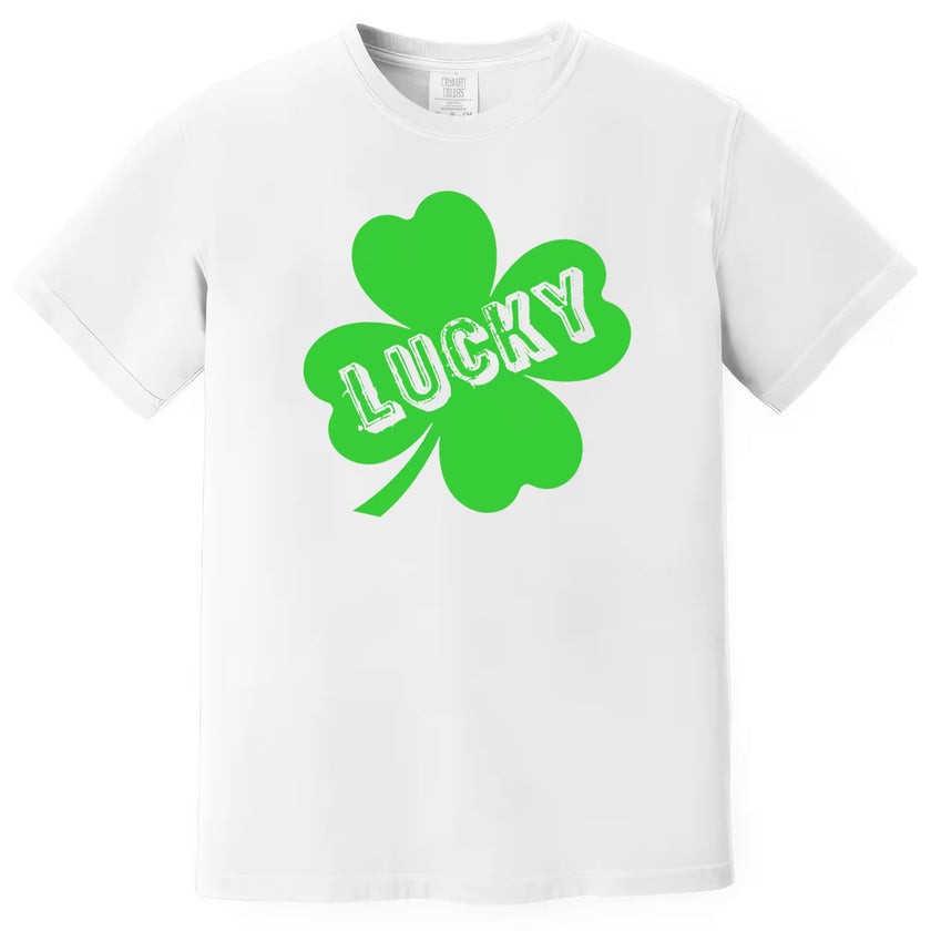 White St. Patrick’s Day Lucky t-shirt flat lay with bold clover graphic and cut-out style “Lucky” lettering for festive style