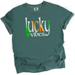 Blue-green St. Patrick’s Day Lucky Vibes t-shirt flat lay featuring bold Irish-colored gradient letters with clover accent