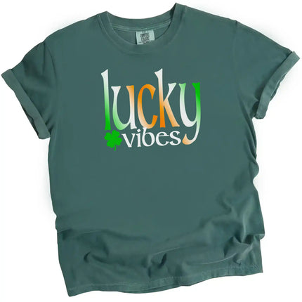 Blue-green St. Patrick’s Day Lucky Vibes t-shirt flat lay featuring bold Irish-colored gradient letters with clover accent