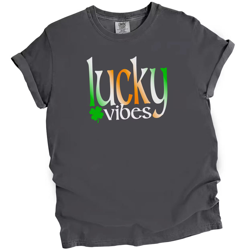 Gray Lucky Vibes St. Patrick’s Day t-shirt flat lay featuring vibrant Irish-colored lettering and small clover design for festive style