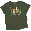 Green St. Patrick’s Day Lucky Vibes t-shirt flat lay showcasing bold gradient “Lucky Vibes” lettering with playful clover accent