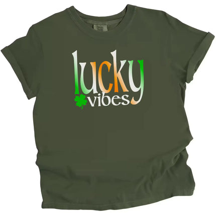 Green St. Patrick’s Day Lucky Vibes t-shirt flat lay showcasing bold gradient “Lucky Vibes” lettering with playful clover accent