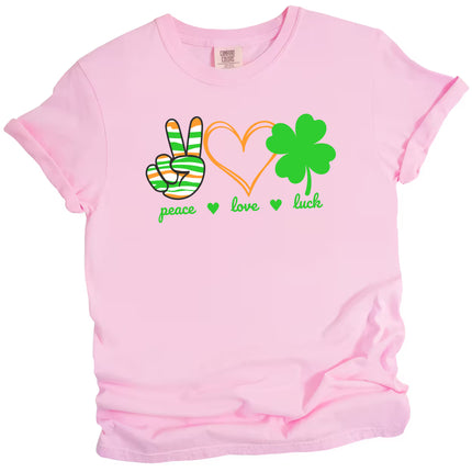 Pink Peace, Love, Luck t-shirt flat lay with cheerful orange hearts, green clover, and festive St. Patrick’s Day design