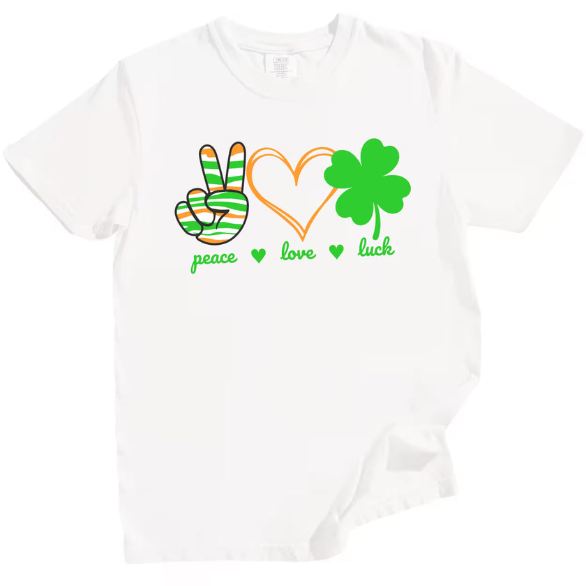 White St. Patrick’s Day Peace, Love, Luck t-shirt flat lay featuring vibrant symbols and bold lettering for holiday fun