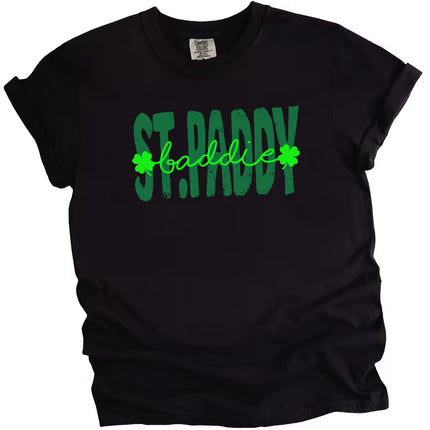 Black St. Paddy Baddie t-shirt flat lay featuring bold green text and high-contrast festive lettering