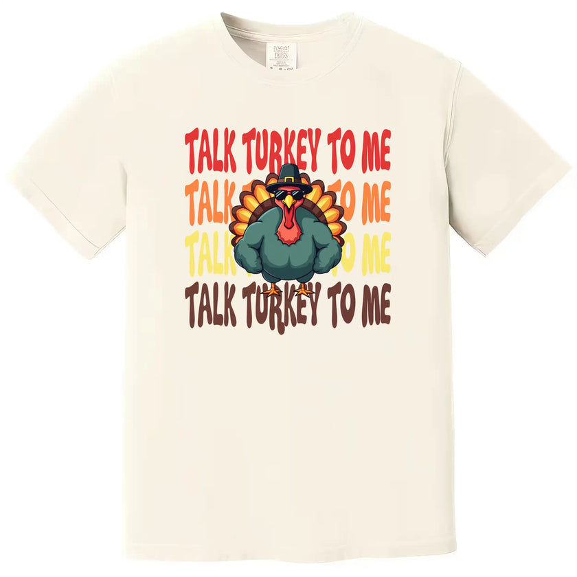 Cream colored Thanksgiving t-shirt featuring ‘Talk Turkey to Me’ text with playful turkey wearing sunglasses and big muscles graphic for festive fall apparel.