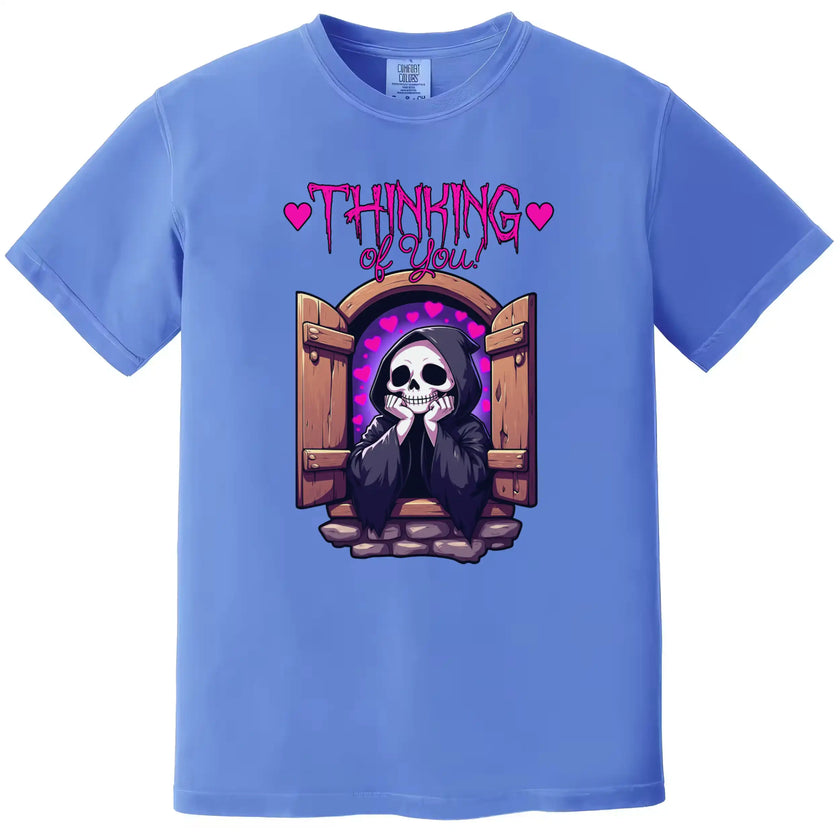 Dark humor t-shirt in blue, grim reaper leaning out castle window with hearts, ‘Thinking of You’ cute romantic graphic design