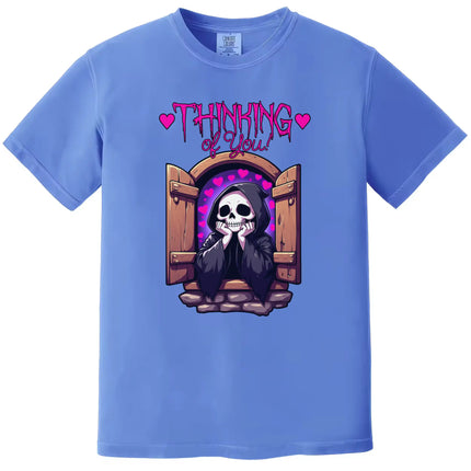 Dark humor t-shirt in blue, grim reaper leaning out castle window with hearts, ‘Thinking of You’ cute romantic graphic design