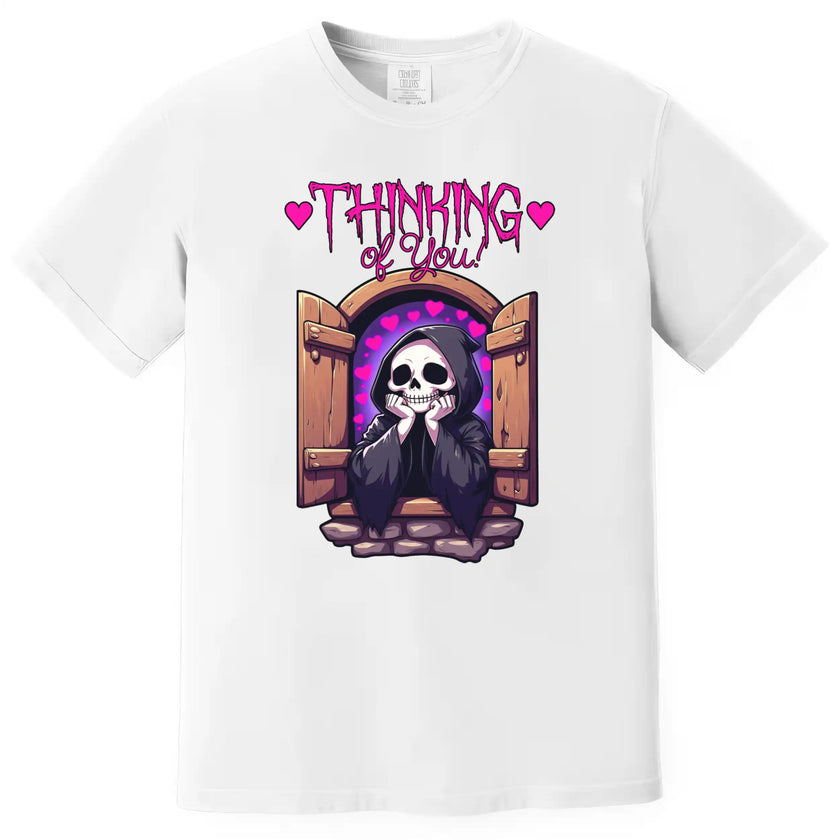 Cute ‘Thinking of You’ t-shirt in white, grim reaper with hearts leaning from castle window, soft spooky romantic graphic tee.