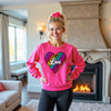 Hot pink sweatshirt featuring colorful animal print heart, white “Love” text, bright studio flat lay