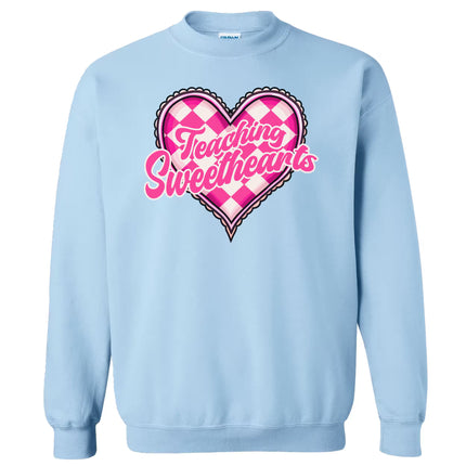 Light blue sweatshirt flat lay featuring “Teaching Sweethearts” text with cute checkered heart design