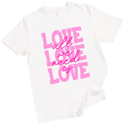 White ‘All We Need Is Love’ tee with pink lettering and heart, flat lay highlighting classic romantic Valentine’s look