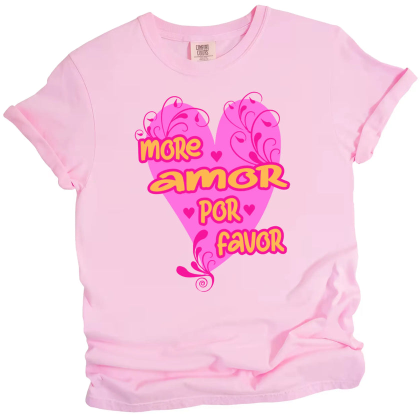 Pink More Amor Por Favor tee showing hot pink heart and bold orange lettering, flat lay on white surface.
