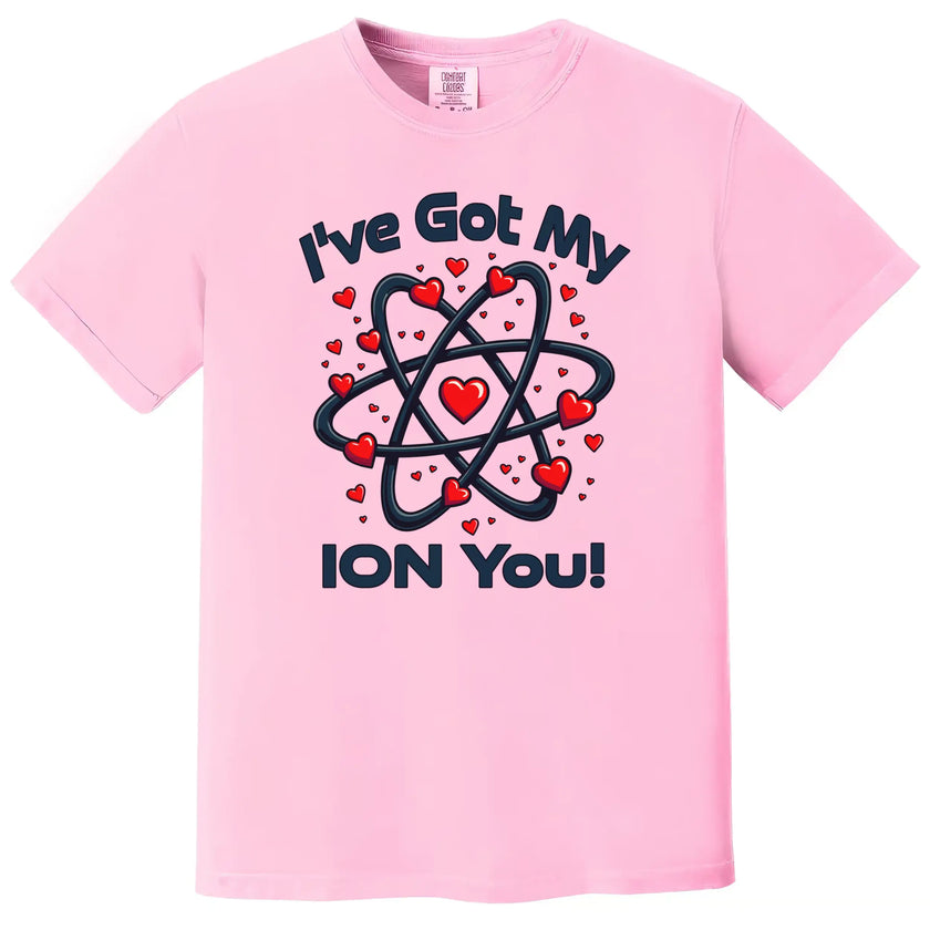 Pink Valentine’s Day chemistry tee laid flat, featuring a fun “I’ve Got My Ion You” design with heart accents.