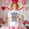 Female model wearing a white “I’ve Got My Ion You” chemistry Valentine shirt standing in a Valentine’s-themed bedroom with festive décor.